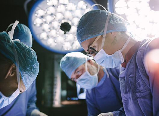 Concentrated surgeon performing surgery with her team